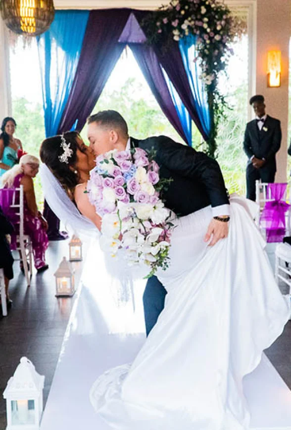 newlyweds kisses on front of the isle