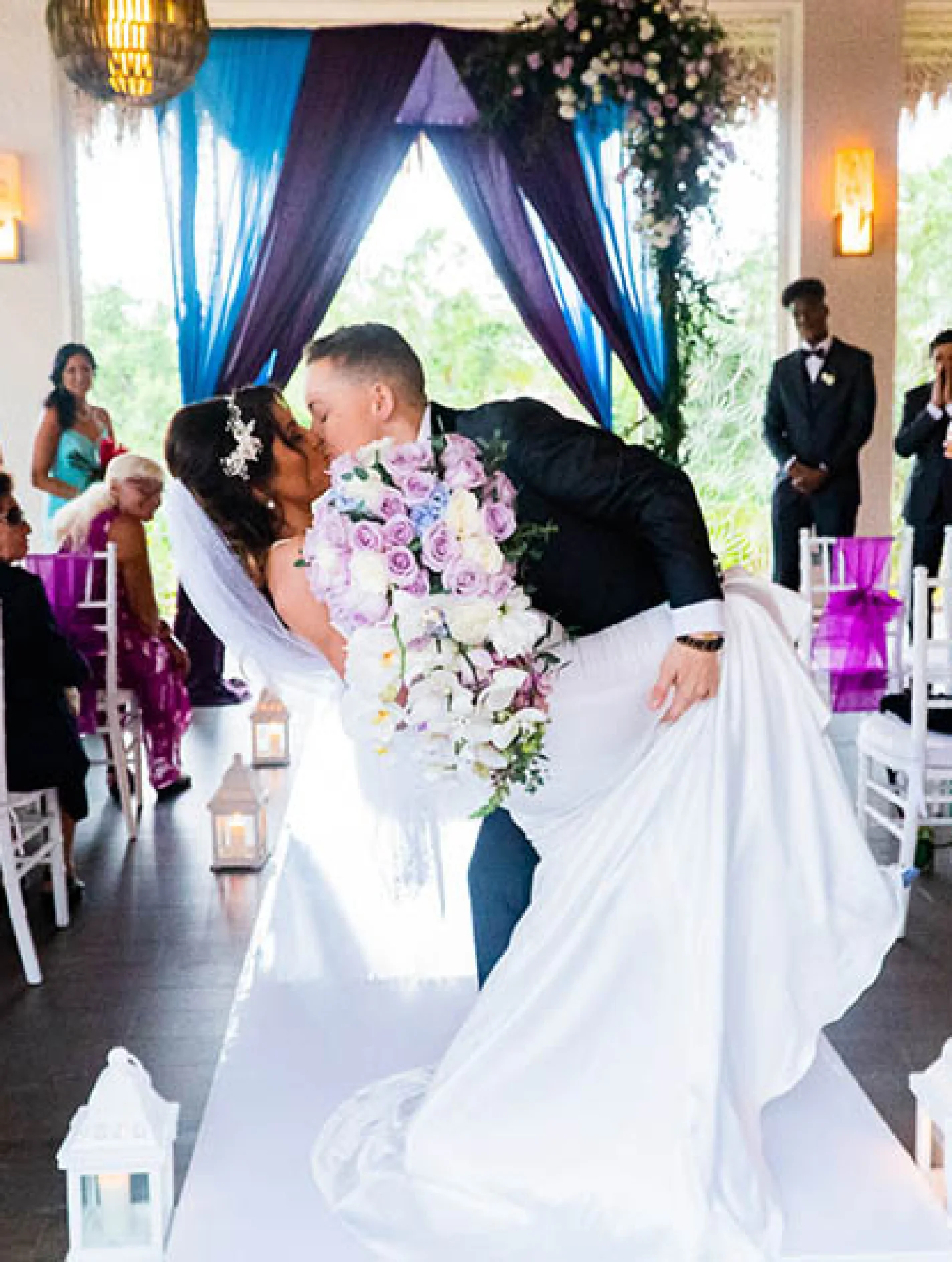 newlyweds kisses on front of the isle