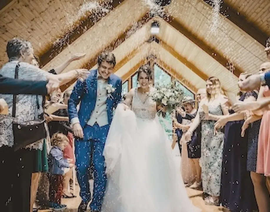 Newlyweds walking through a shower of confetti at a wedding ceremony in Mexico