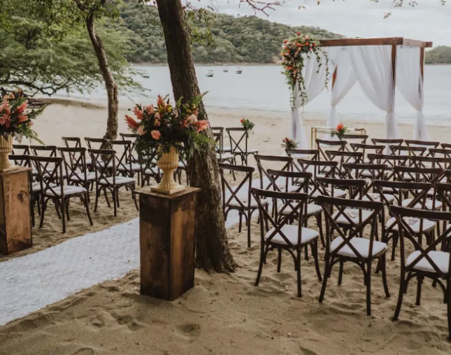 Beachfront wedding ceremony setup with wooden cross-back chairs at Dreams Las Mareas, Costa Rica