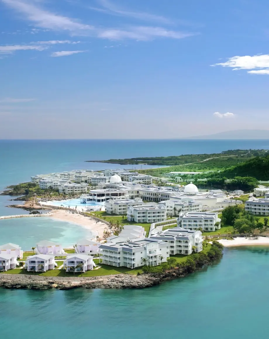 Aerial view of a coastal resort on a peninsula with white buildings and turquoise water in Lucea, Jamaica