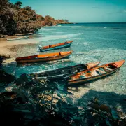 Colorful wooden fishing boats anchored in clear turquoise water along the coast of Jamaica