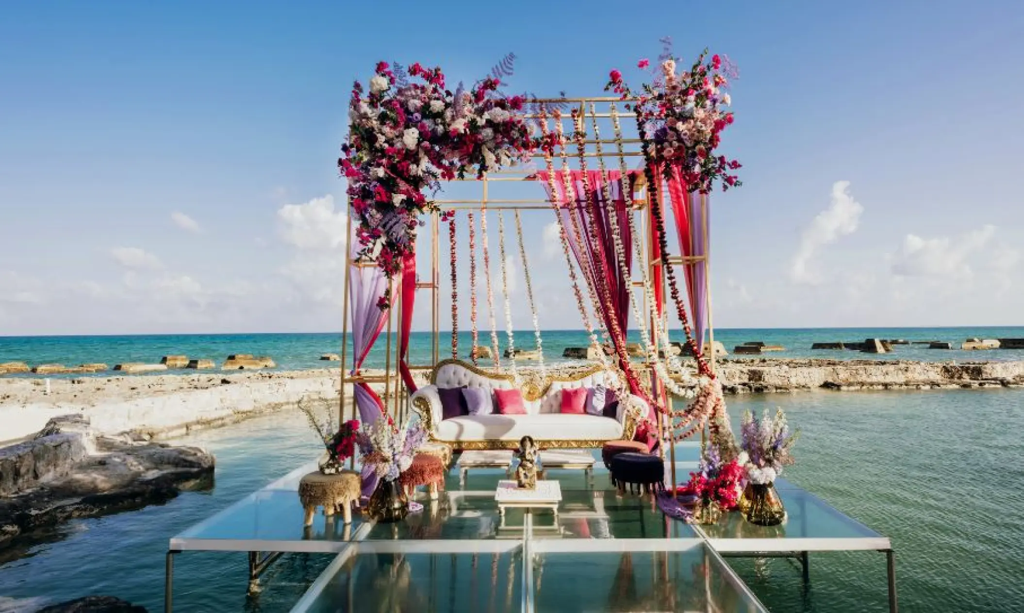 Glass platform wedding reception setup with floral mandap at El Dorado Casitas Royale, Riviera Maya