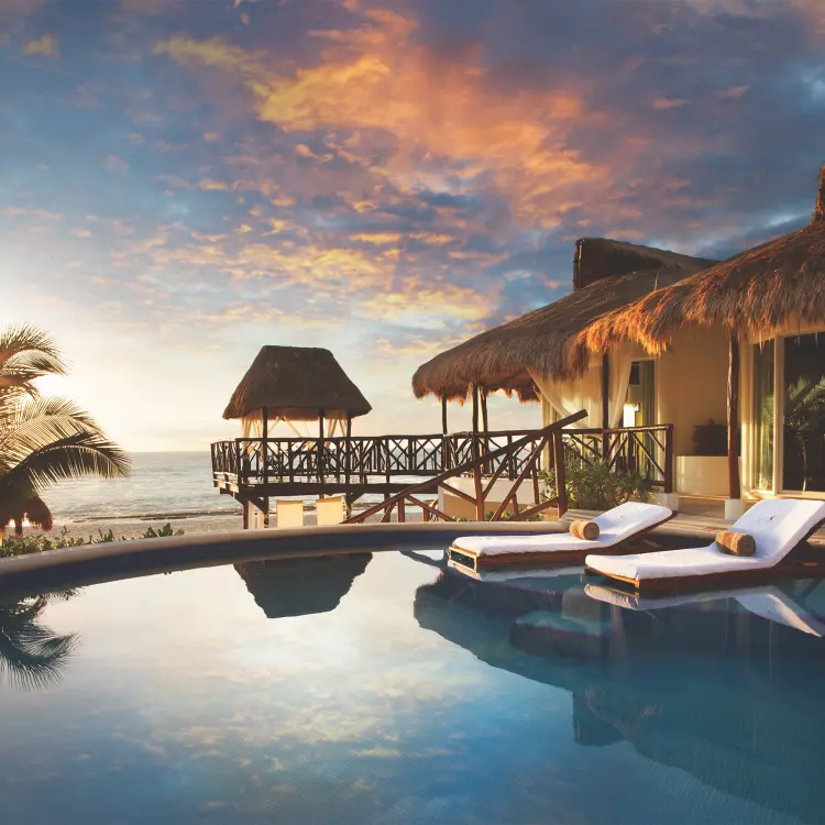 El Dorado Casitas Royale swim-up pool and thatched-roof casitas at sunset, Riviera Maya