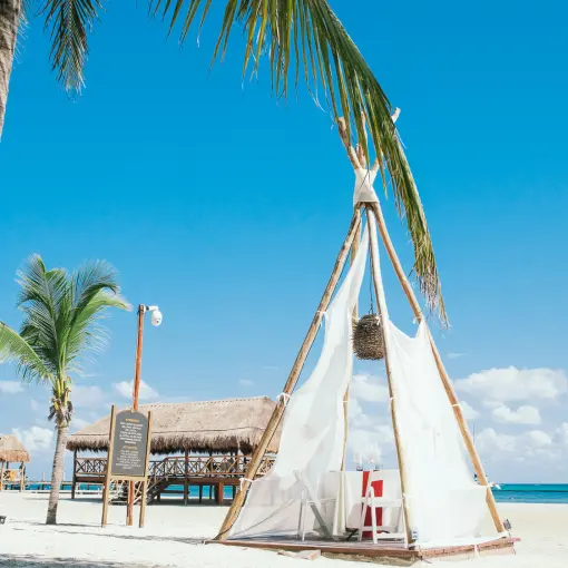 Beachfront tipi dinner setup on the sand at El Dorado Maroma, Riviera Maya