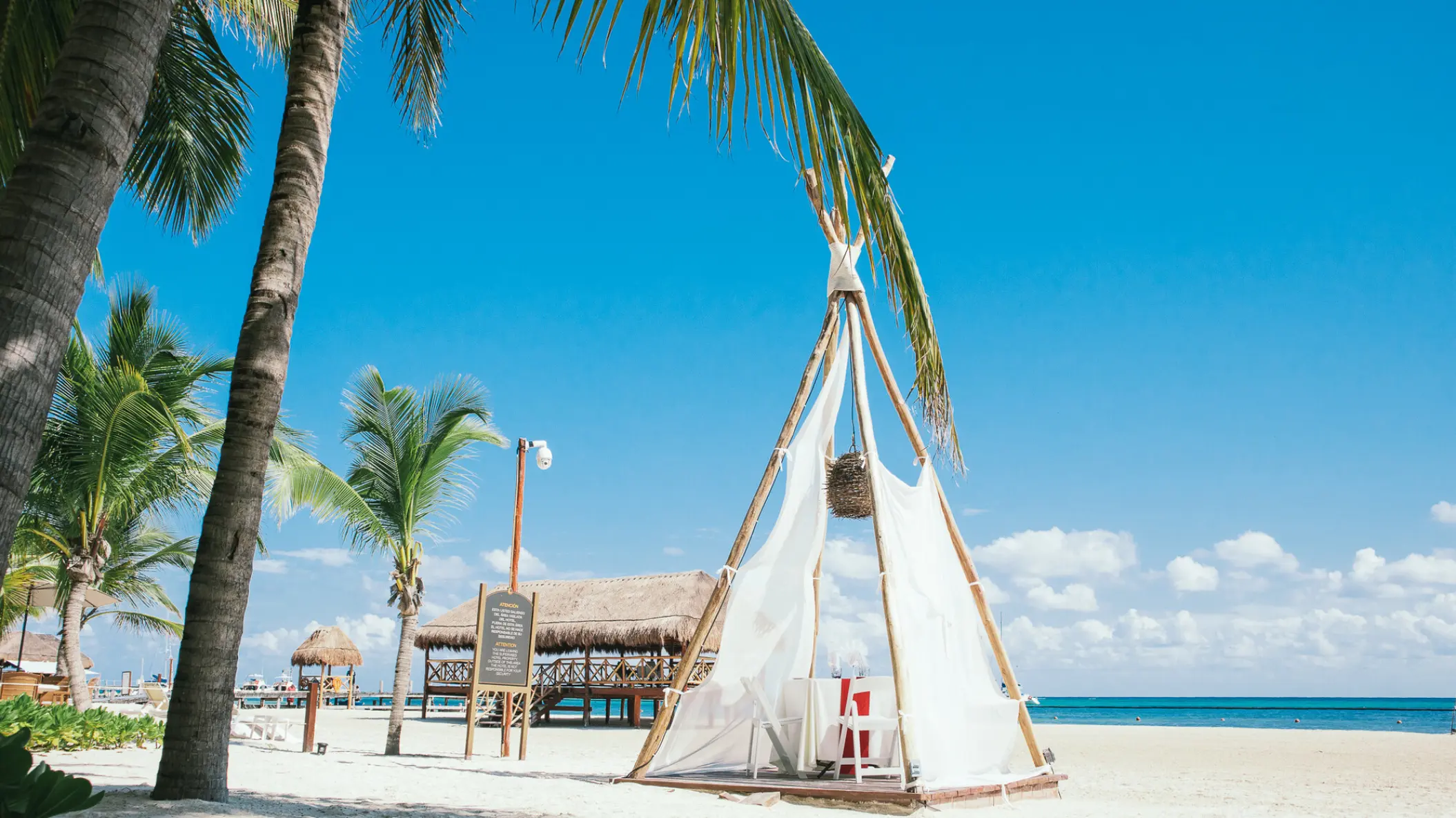 Beachfront tipi dinner setup on the sand at El Dorado Maroma, Riviera Maya