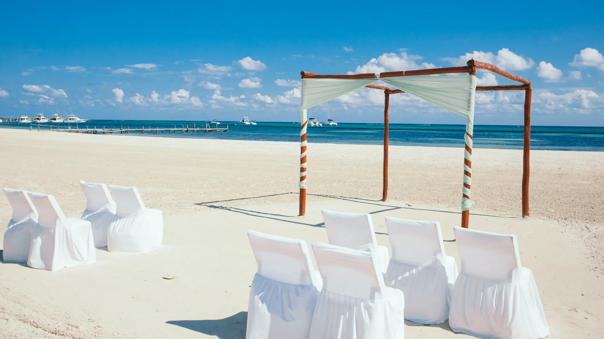 Beachfront wedding ceremony setup with a wooden gazebo at El Dorado Maroma, Riviera Maya