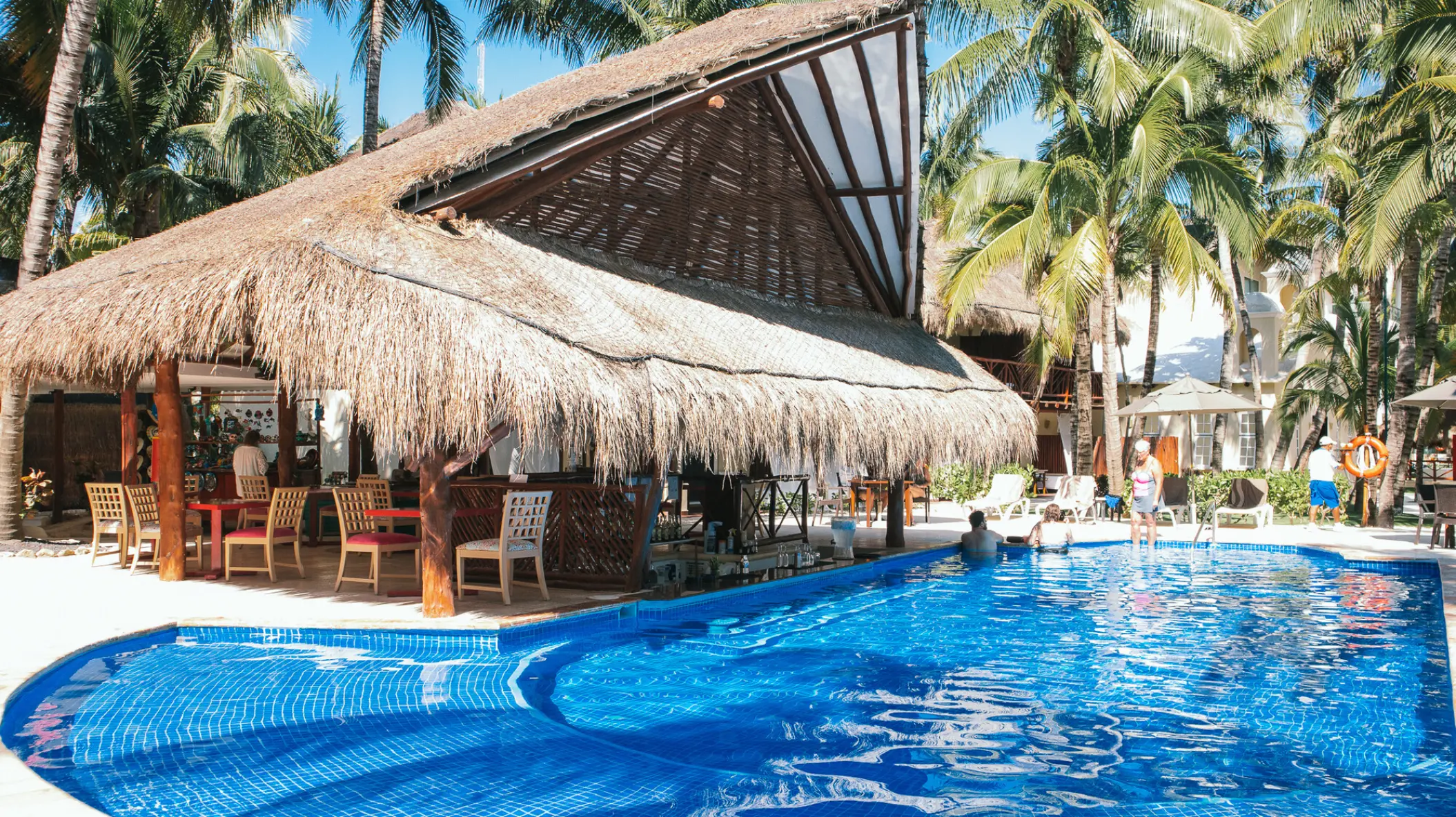 Swim-up bar under a thatched palapa roof at El Dorado Maroma, Riviera Maya
