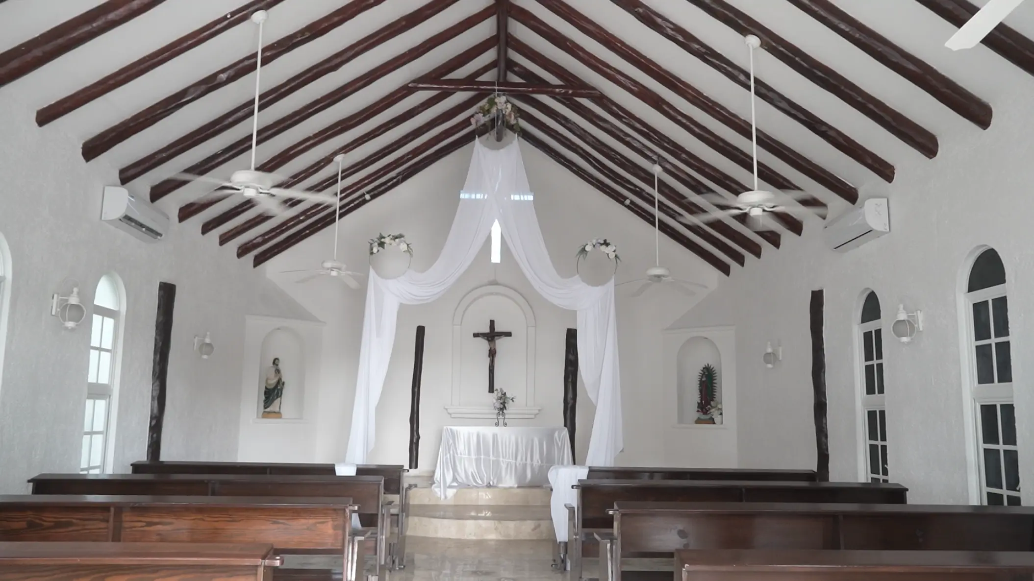 Chapel wedding ceremony venue with wooden beams and white drapery at El Dorado Casitas Royale, Riviera Maya