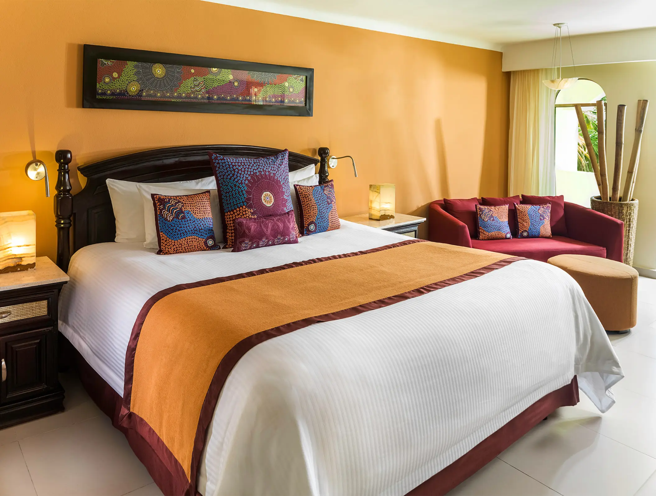 Luxury suite with king bed and colorful textiles at El Dorado Royale, Riviera Maya