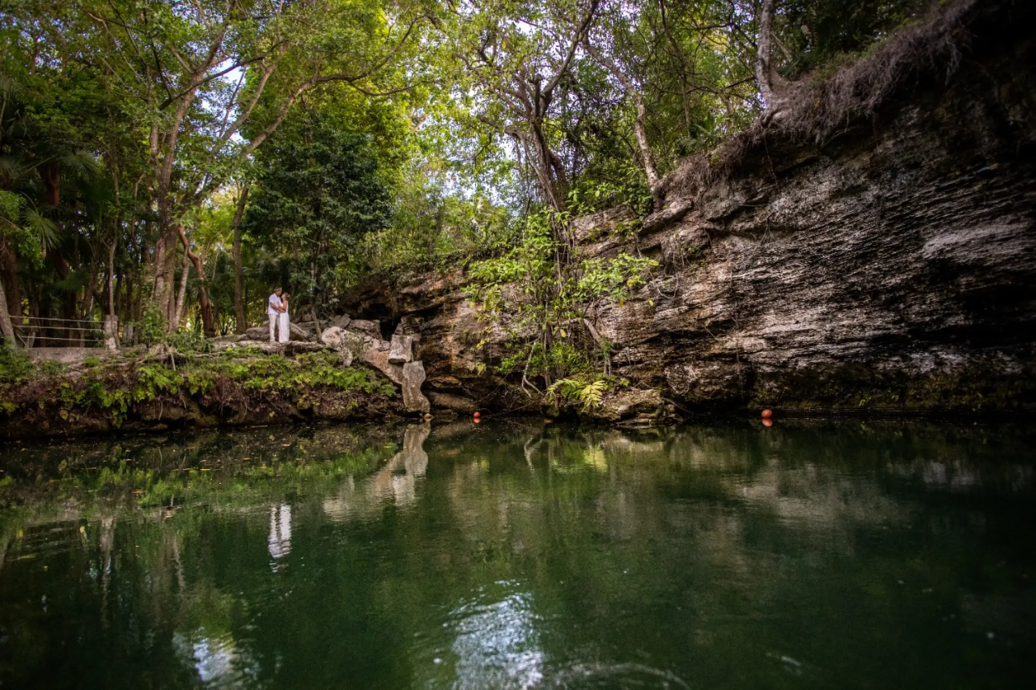 A couple standing by the natural cenote pool at El Dorado Royale, Riviera Maya
