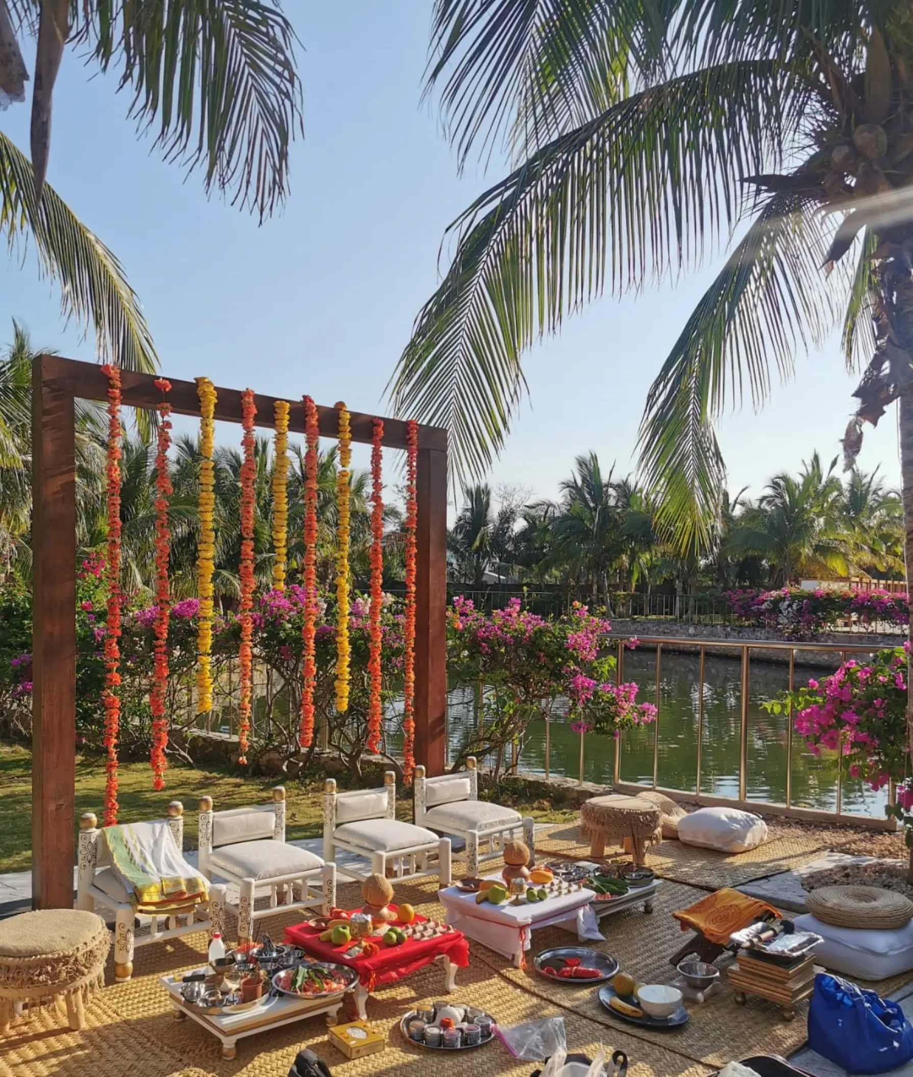Garden wedding ceremony setup with floral garlands and low seating at El Dorado Royale, Riviera Maya