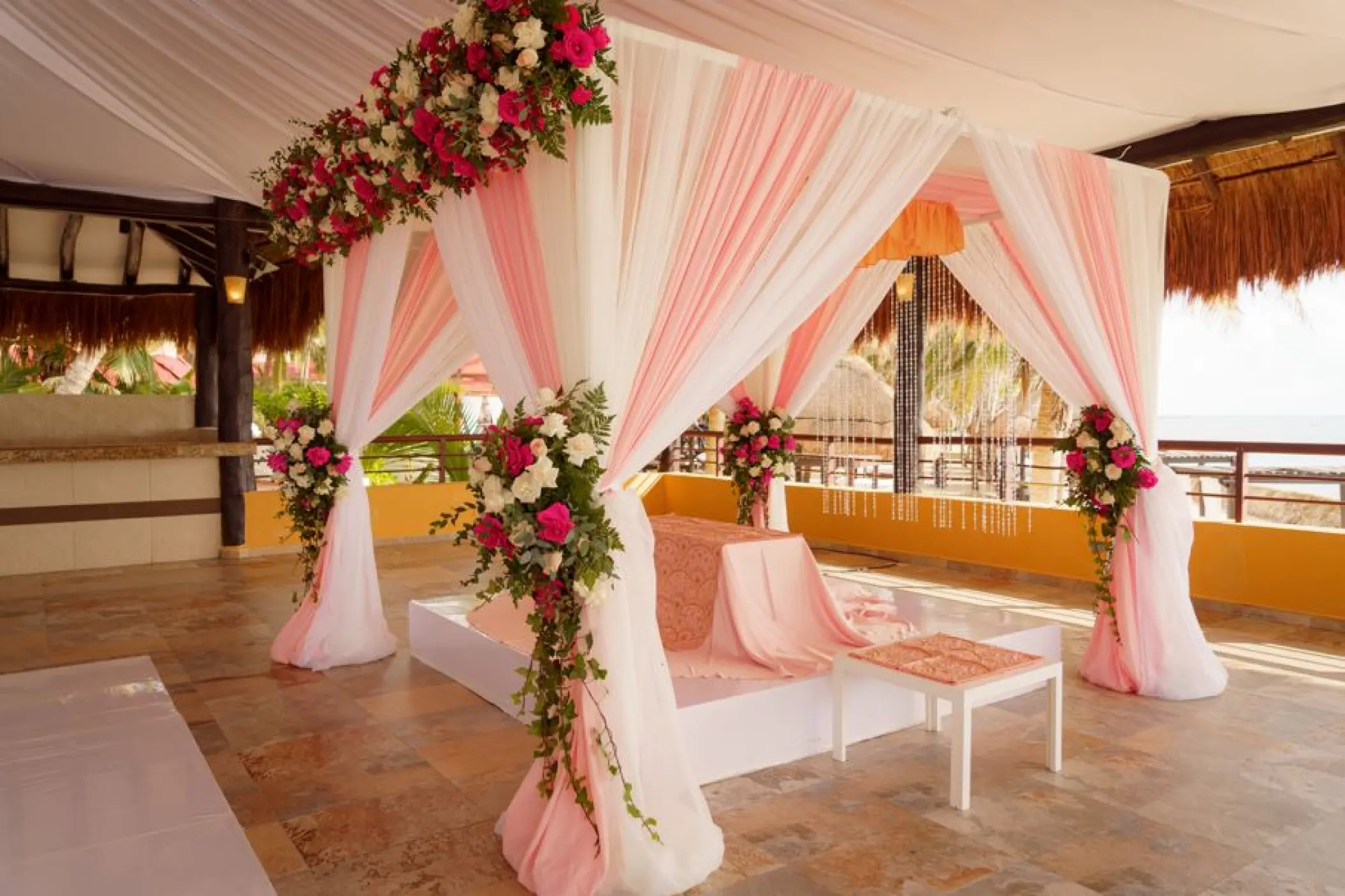 Palapa wedding ceremony setup with pink and white draping at El Dorado Seaside Palms, Riviera Maya