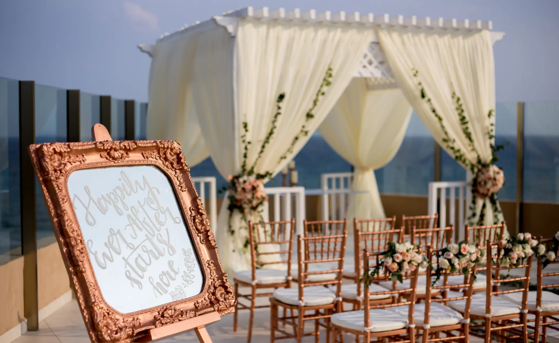 Sky deck wedding ceremony setup with white floral gazebo and draped fabric at El Dorado Seaside Palms, Riviera Maya
