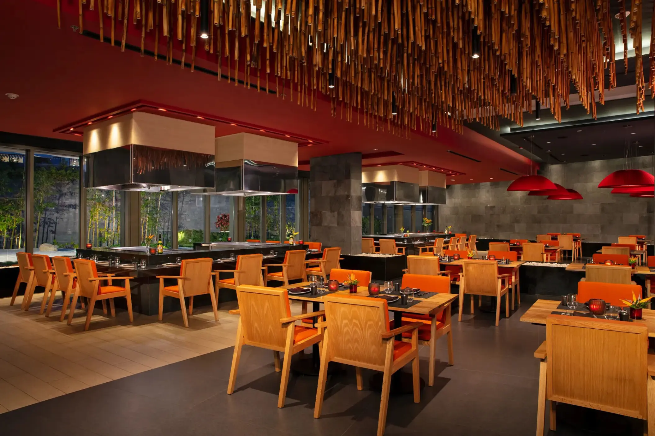 Himitsu Asian restaurant with orange seating and teppanyaki grills at Secrets Bahia Mita, Puerto Vallarta