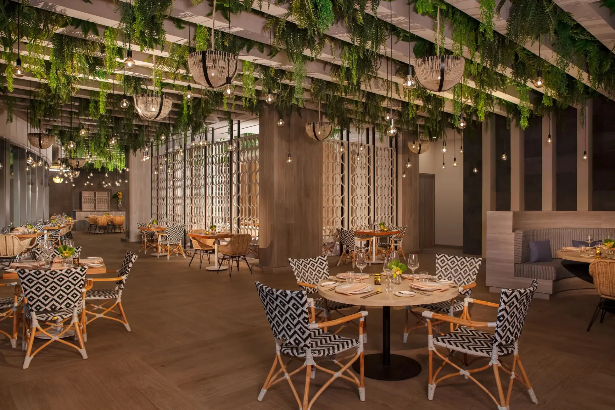Portofino restaurant dining area with hanging greenery and patterned chairs at Secrets Bahia Mita, Puerto Vallarta