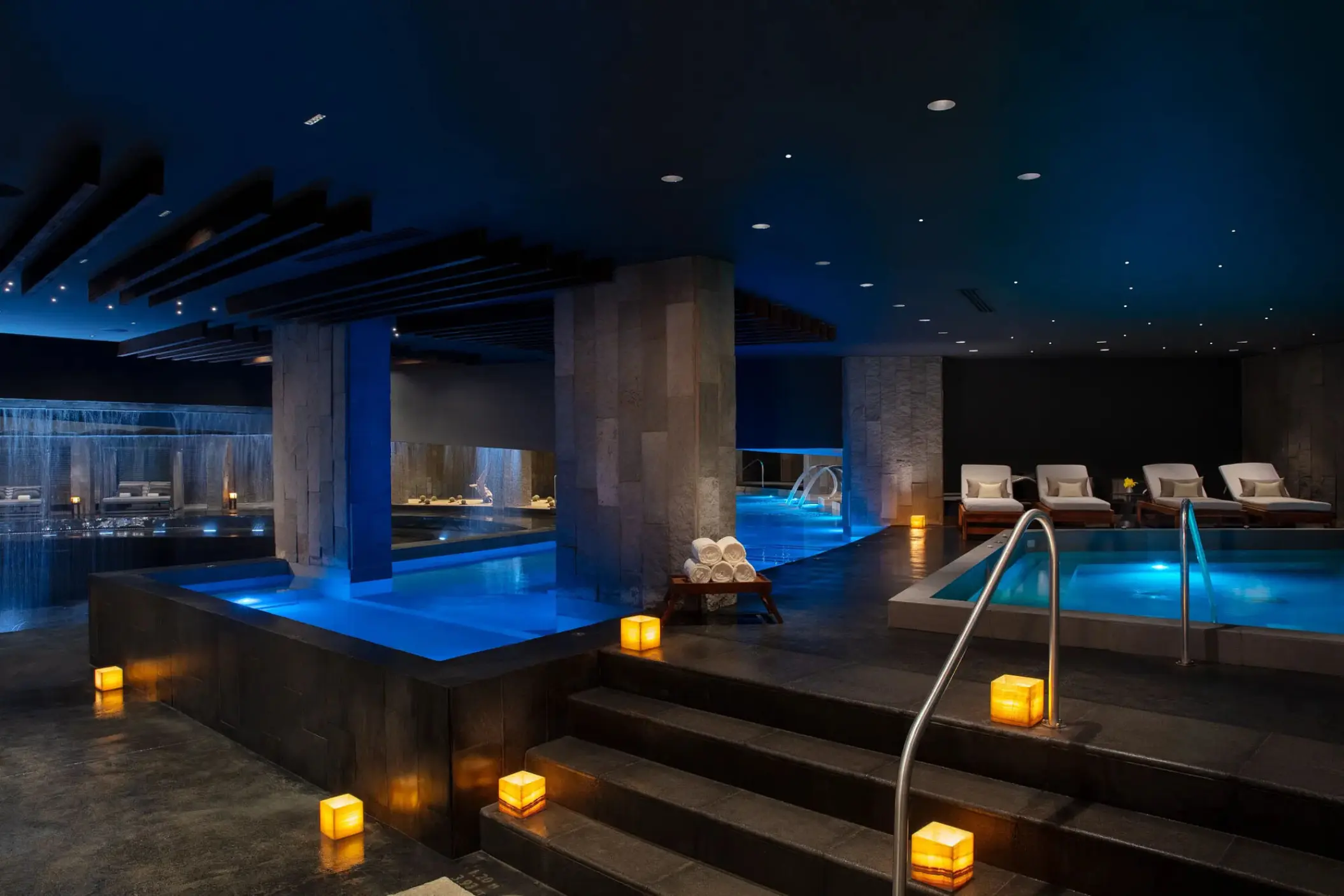 Indoor spa hydrotherapy circuit with blue pools and candle lighting at Secrets Bahia Mita, Puerto Vallarta