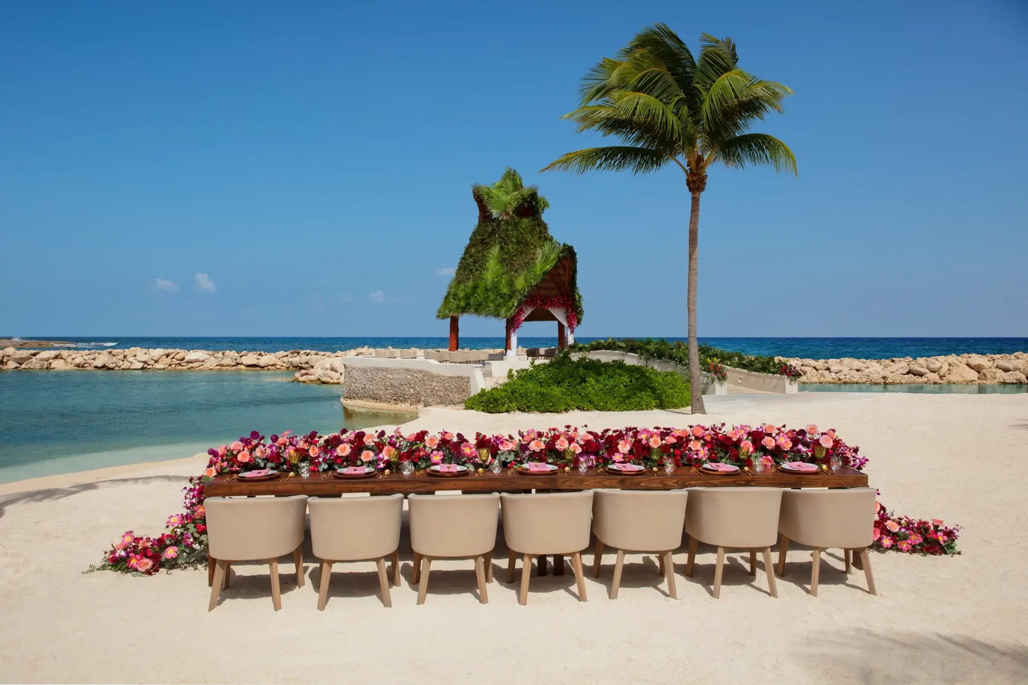 Beachfront wedding reception setup with floral runner at Dreams Aventuras, Riviera Maya