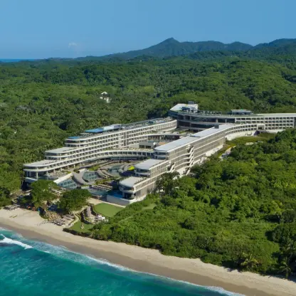 Aerial view of Dreams Bahia Mita resort buildings nestled in lush jungle on the beach, Puerto Vallarta