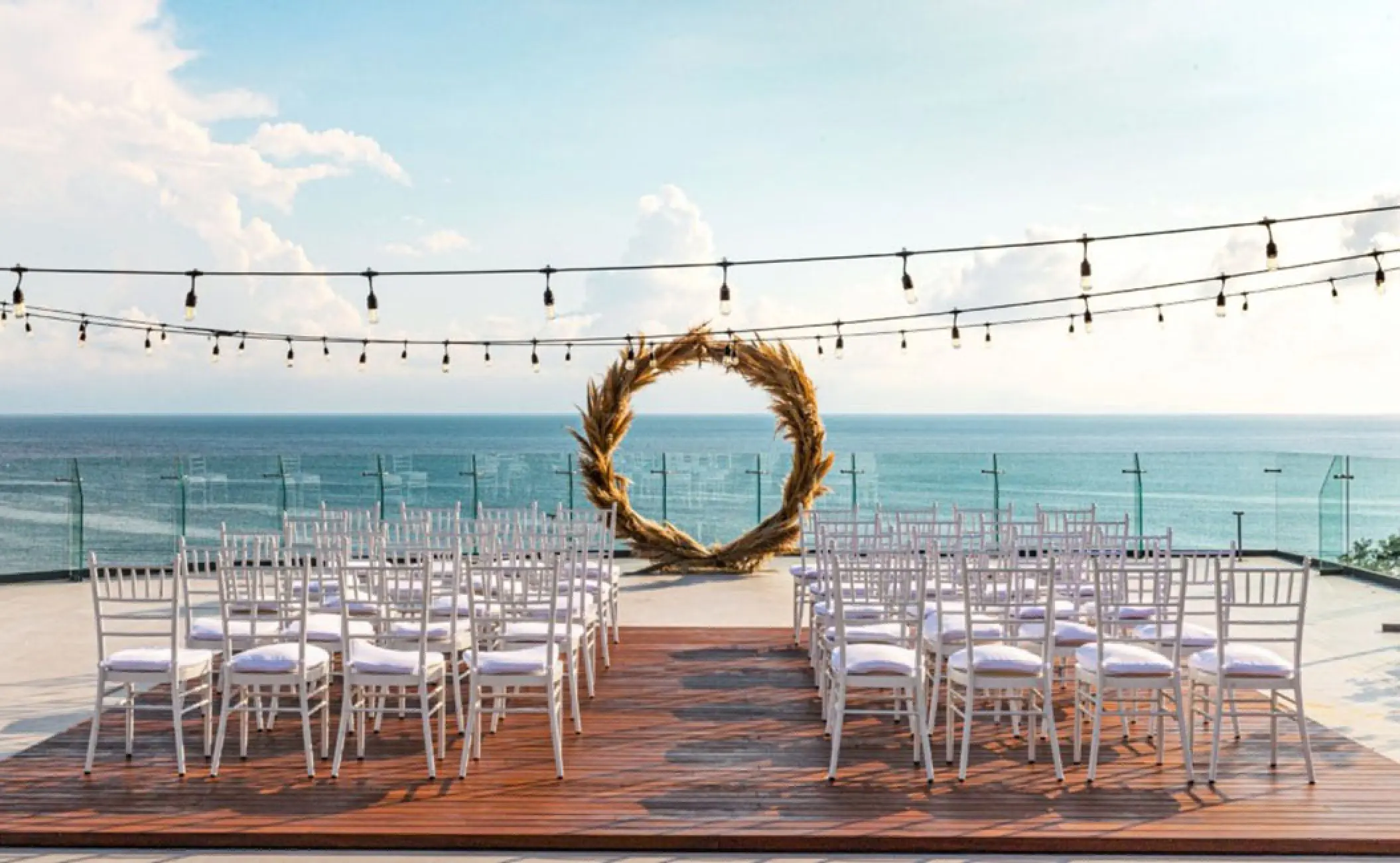 Terrace wedding ceremony at Secrets Bahia Mita with a pampas grass arch and ocean views, Puerto Vallarta