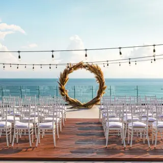 Terrace wedding ceremony at Secrets Bahia Mita with a pampas grass arch and ocean views, Puerto Vallarta
