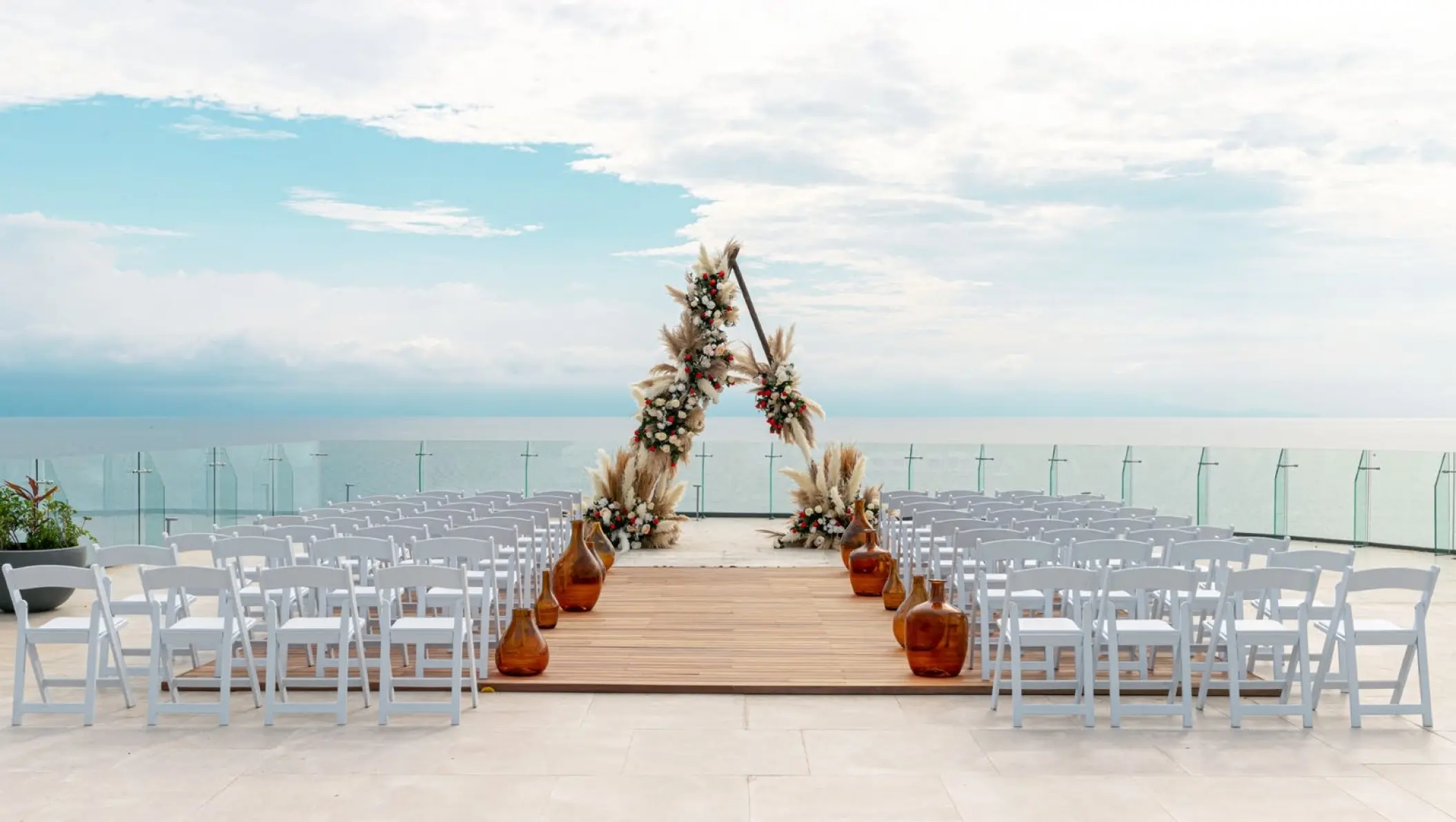 Terrace wedding ceremony at Dreams Bahia Mita with a floral triangle arch, Puerto Vallarta