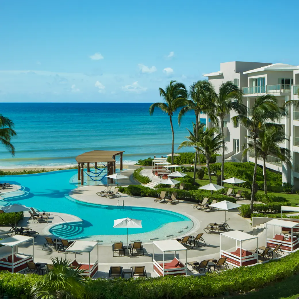 Dreams Jade beachfront pool and lounge area with palm trees, Riviera Maya