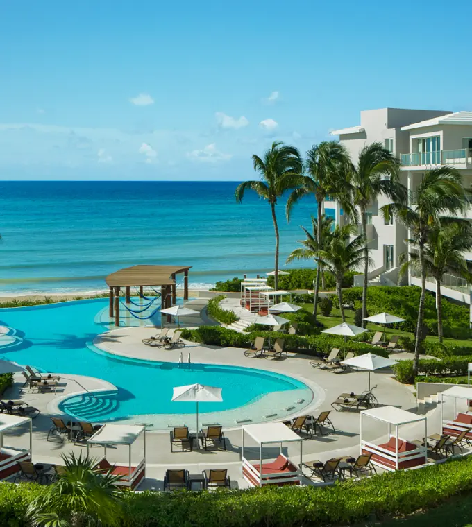 Dreams Jade beachfront pool and lounge area with palm trees, Riviera Maya