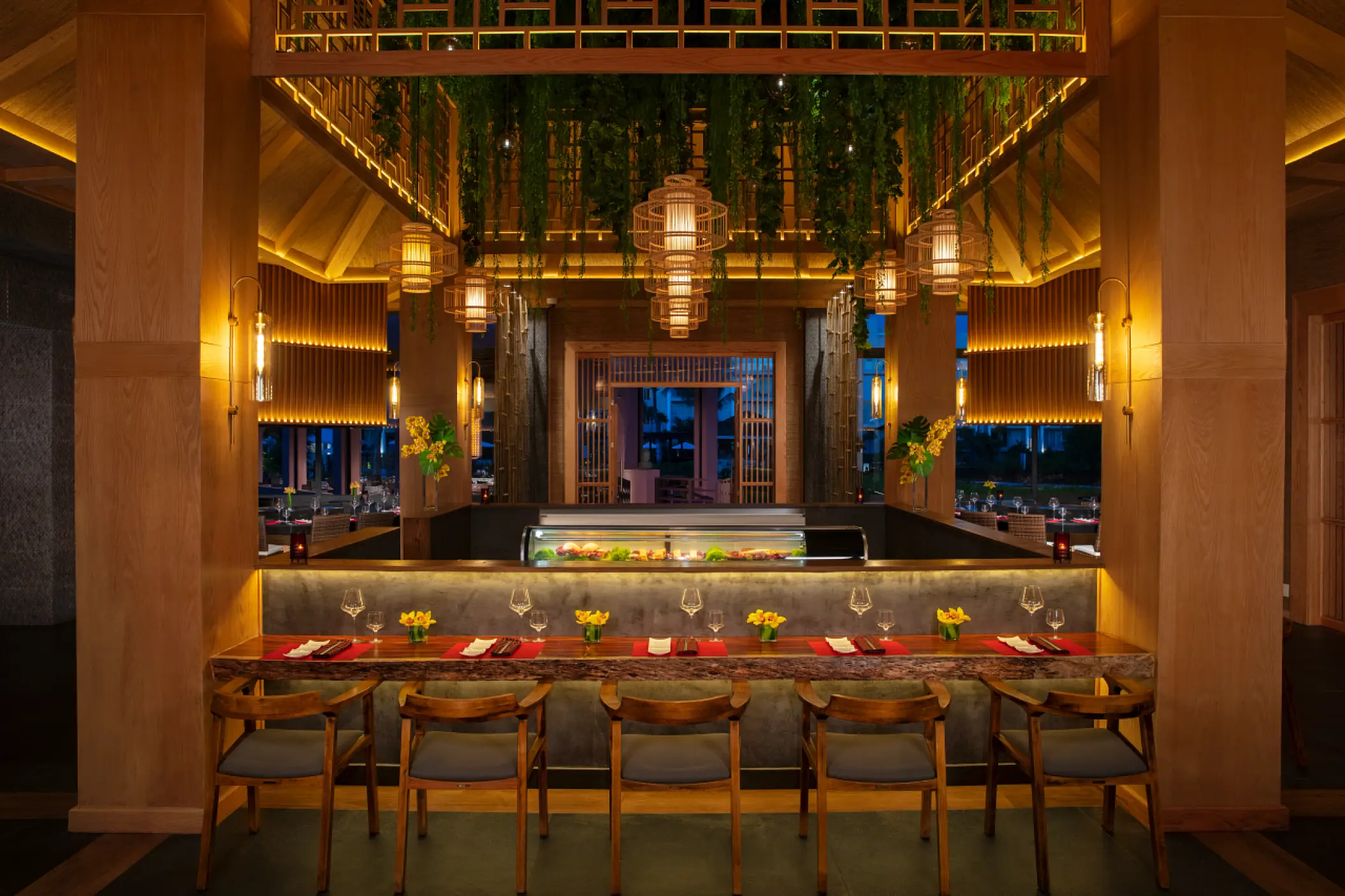 Asian restaurant dining area with hanging plants and lanterns at Dreams Jade, Riviera Maya