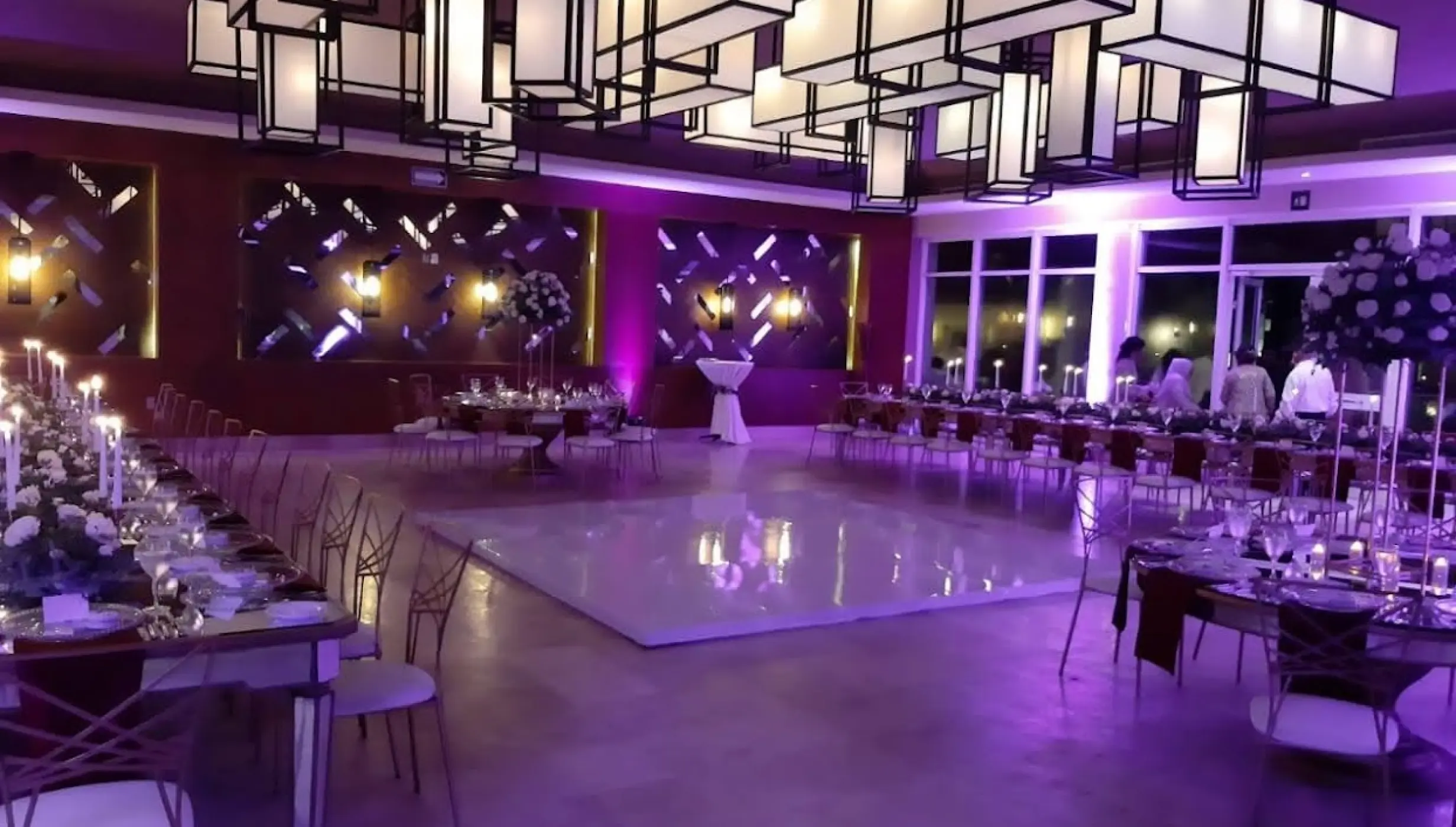 Indoor wedding reception with purple uplighting and white dance floor at Dreams Jade, Riviera Maya