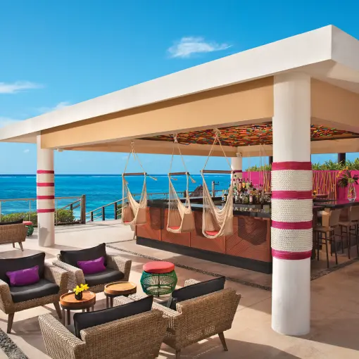 Open-air bar with hammock seating and ocean views at Dreams Jade, Riviera Maya
