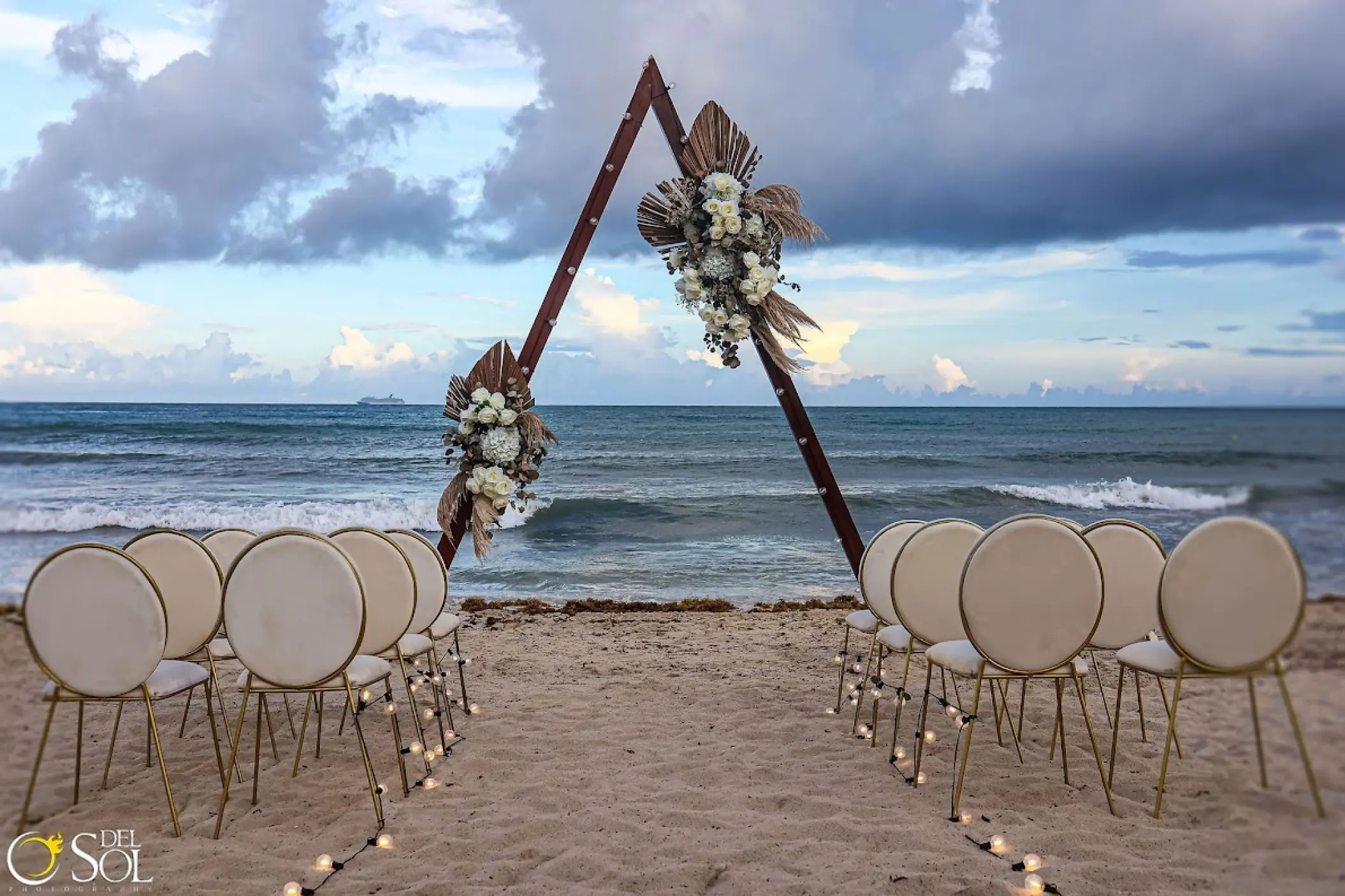 Triangle arch and beach ceremony setup at Dreams Jade, Riviera Maya