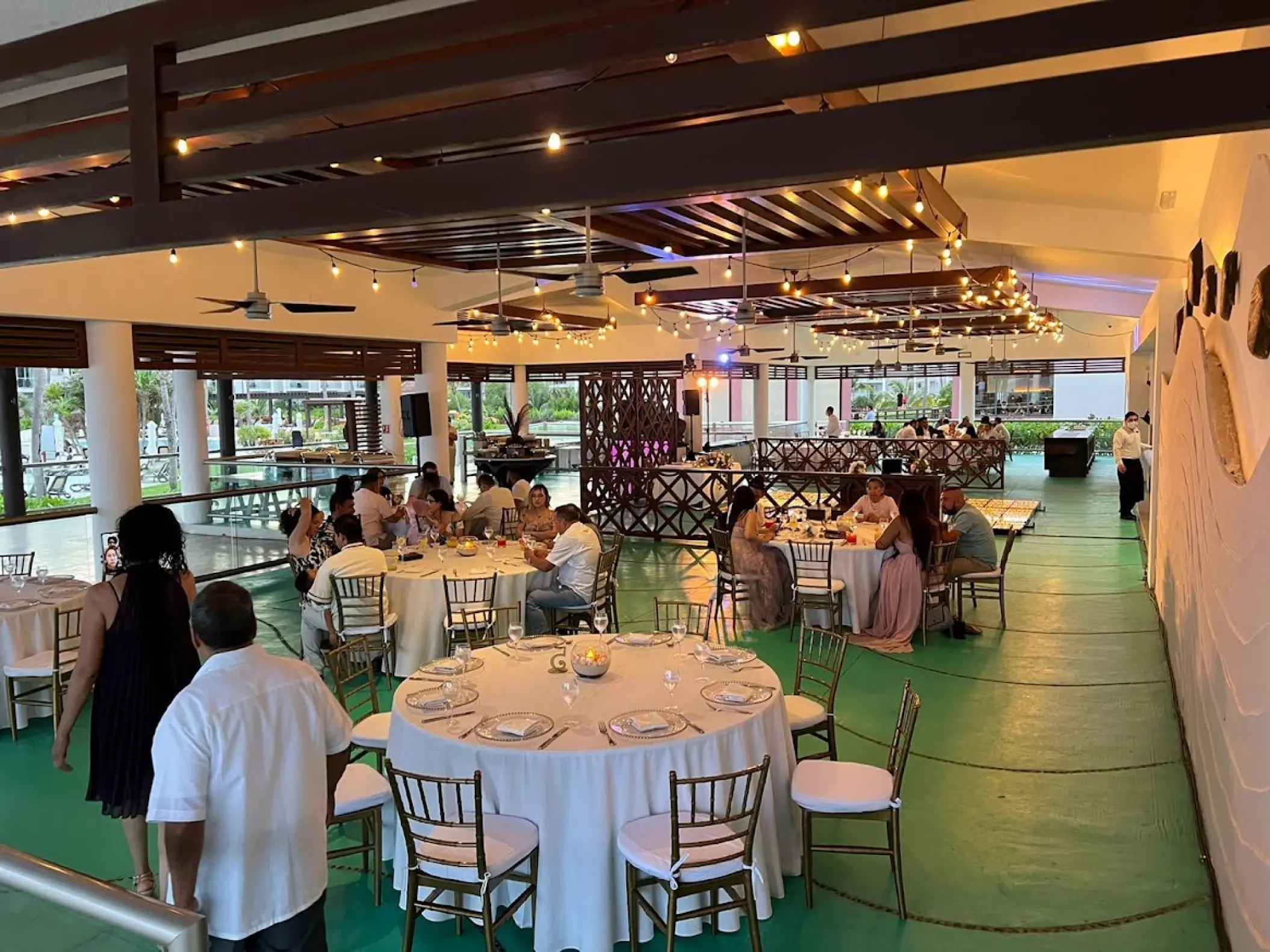 Wedding reception with guests seated at round tables in Castaways restaurant at Dreams Jade, Riviera Maya