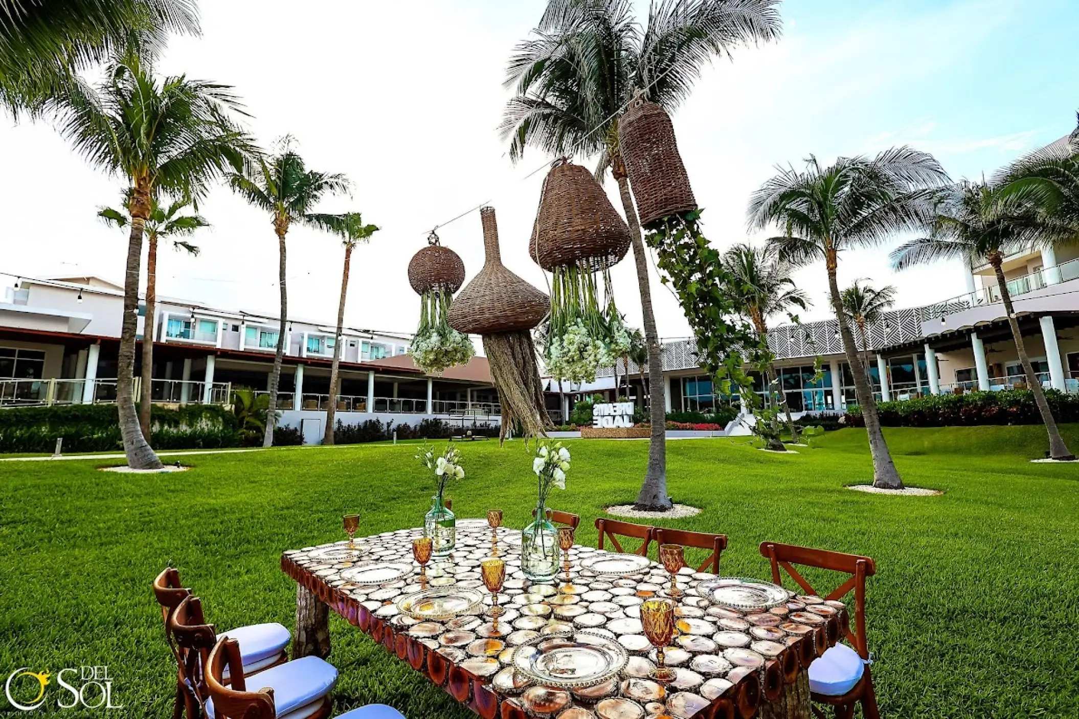 Rustic garden wedding reception table with hanging lanterns at Dreams Jade, Riviera Maya