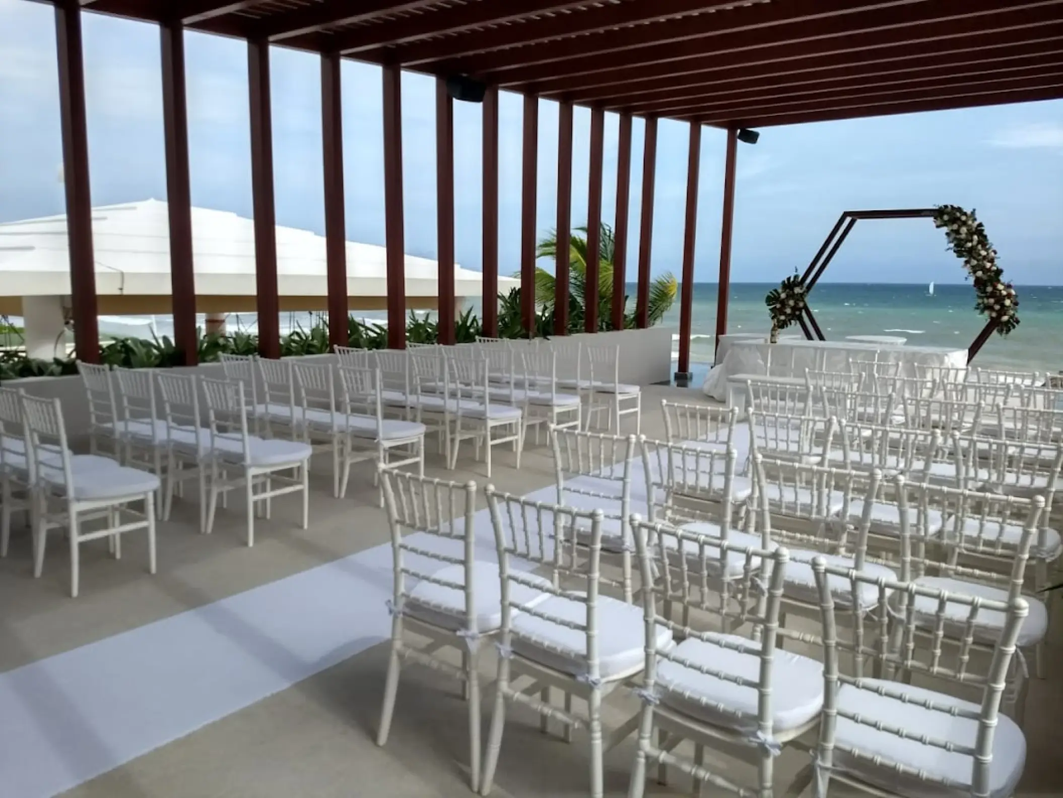 Wedding ceremony setup under a wooden pergola at Dreams Jade, Riviera Maya