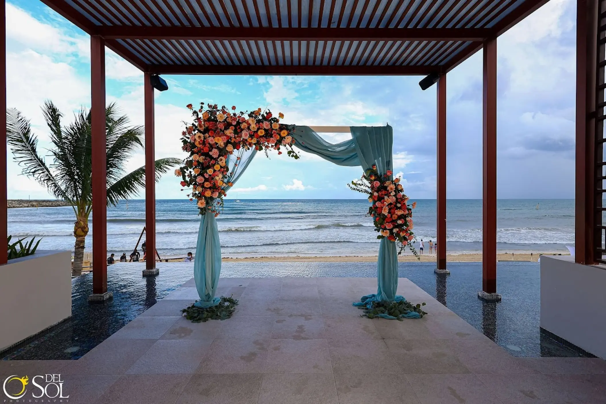 Pergola wedding ceremony setup with flower arch at Dreams Jade, Riviera Maya