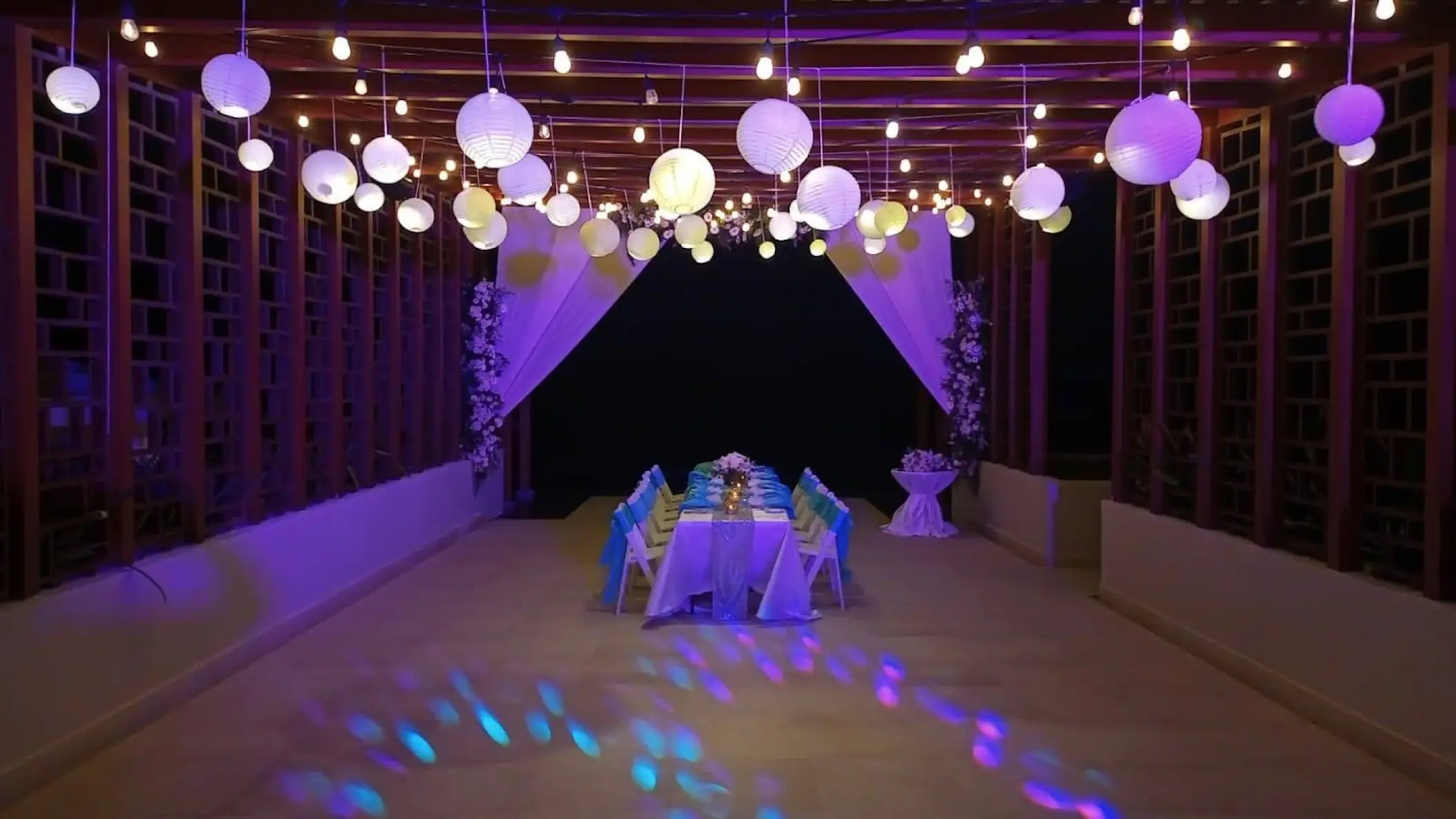 Wedding reception table under purple lights and paper lanterns at Dreams Jade, Riviera Maya