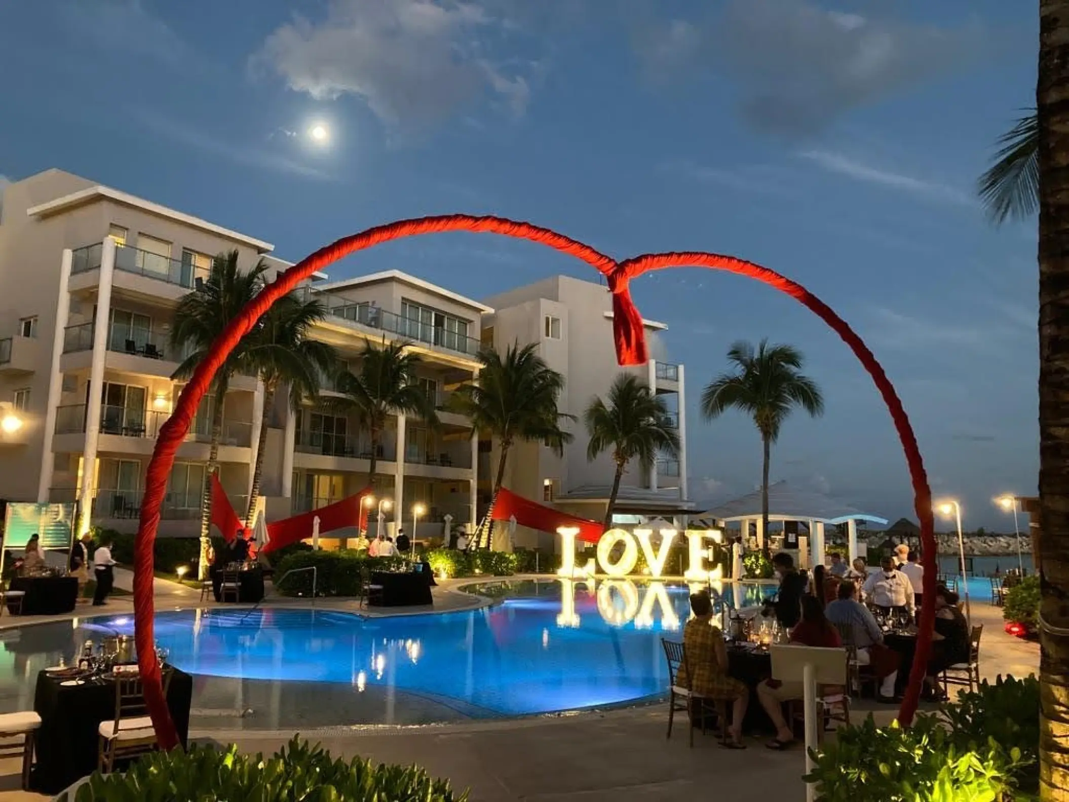 Wedding reception with illuminated LOVE sign by the pool at Dreams Jade, Riviera Maya