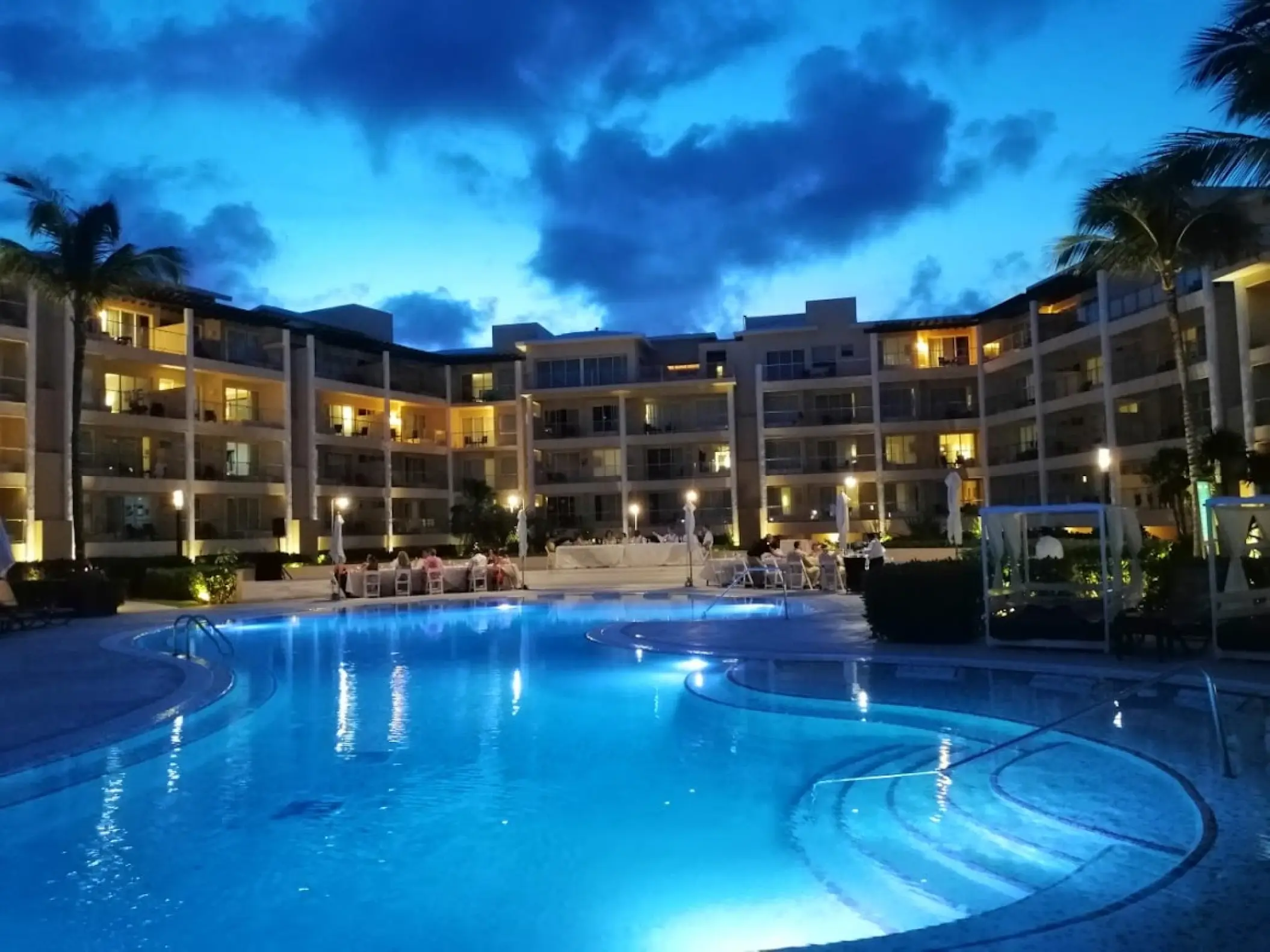 Illuminated swimming pool and guest room balconies at night at Dreams Jade, Riviera Maya