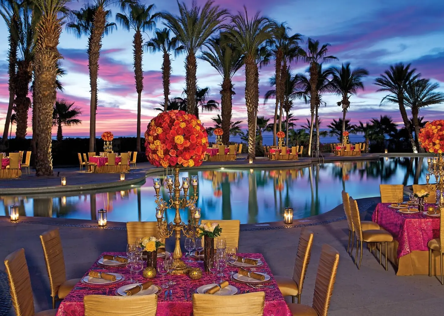 Outdoor wedding reception setup with pink linens around the pool at Dreams Los Cabos, Cabo San Lucas