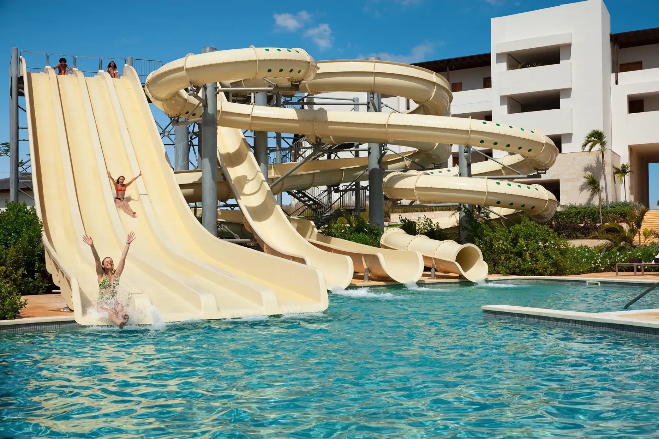 Waterpark with large slides and guests splashing into a pool at Dreams Macao Beach, Punta Cana