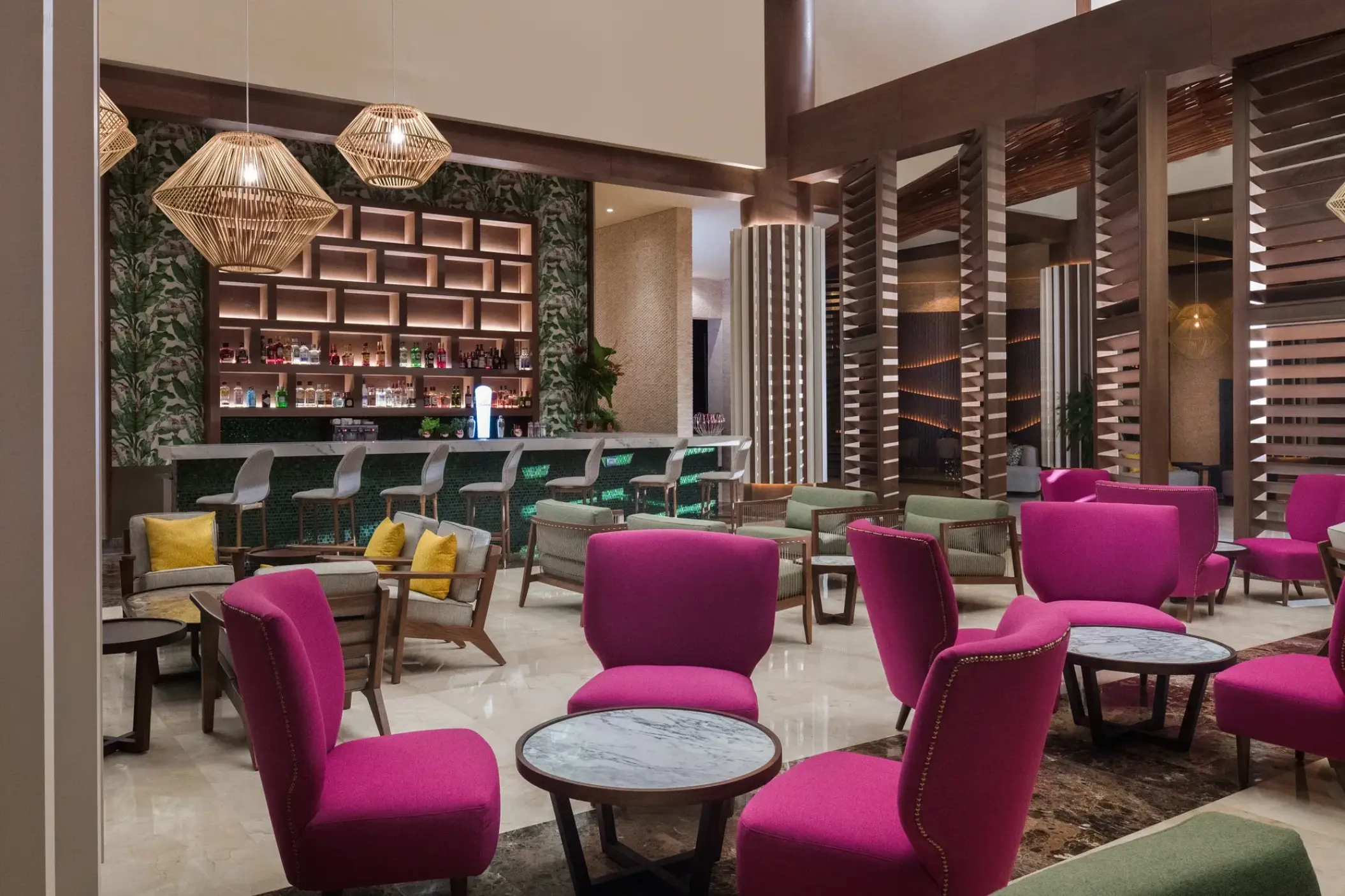 Rendezvous bar lounge with pink armchairs and modern lighting at Dreams Macao Beach, Punta Cana