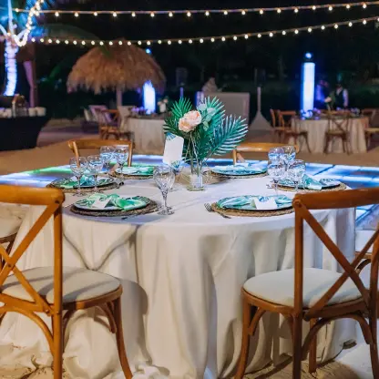 Beach wedding reception with cross-back chairs and string lights at Dreams Macao Beach, Punta Cana
