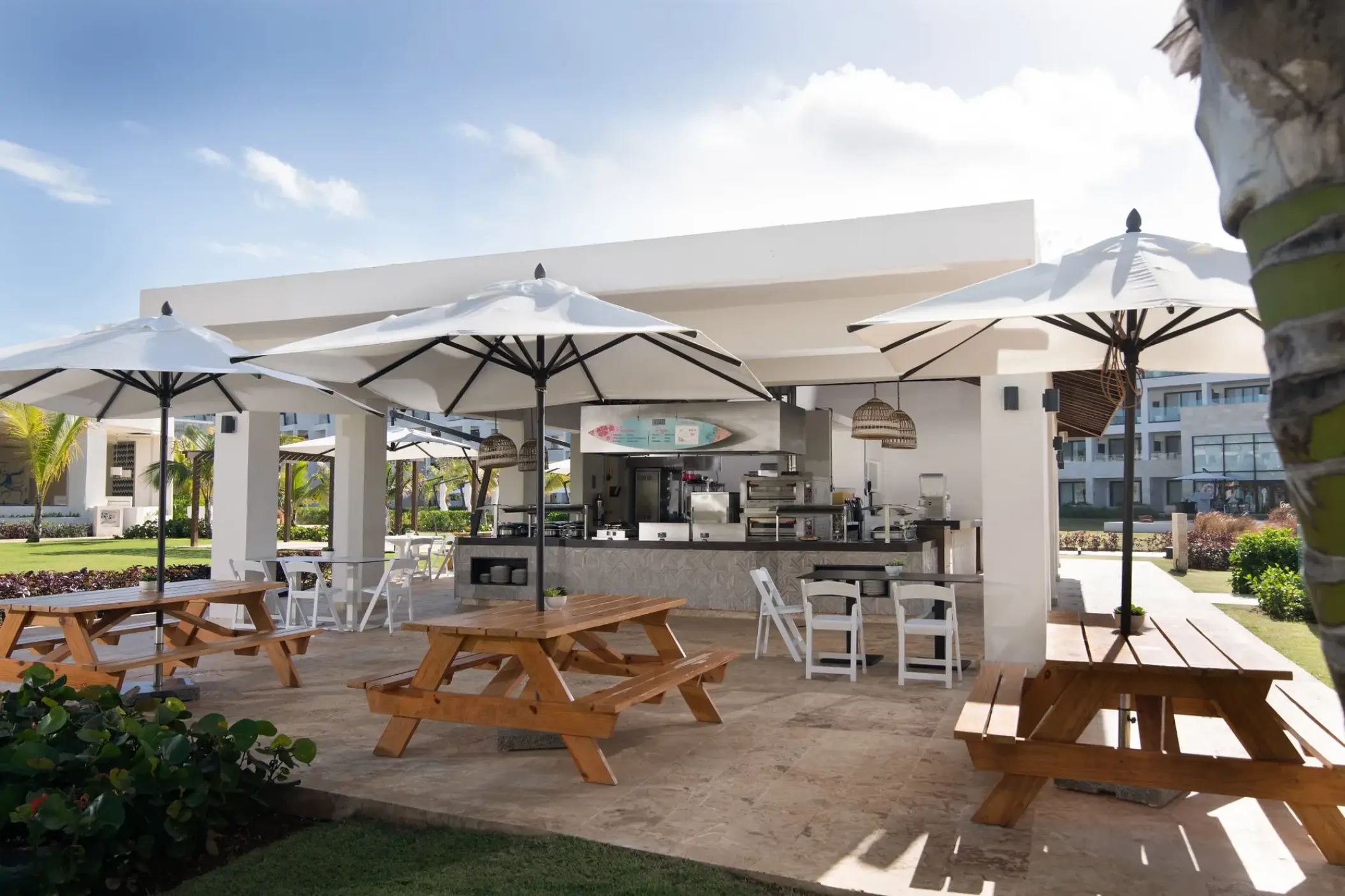 Dreams Macao Beach Barefoot Grill outdoor dining area with picnic tables and umbrellas, Punta Cana