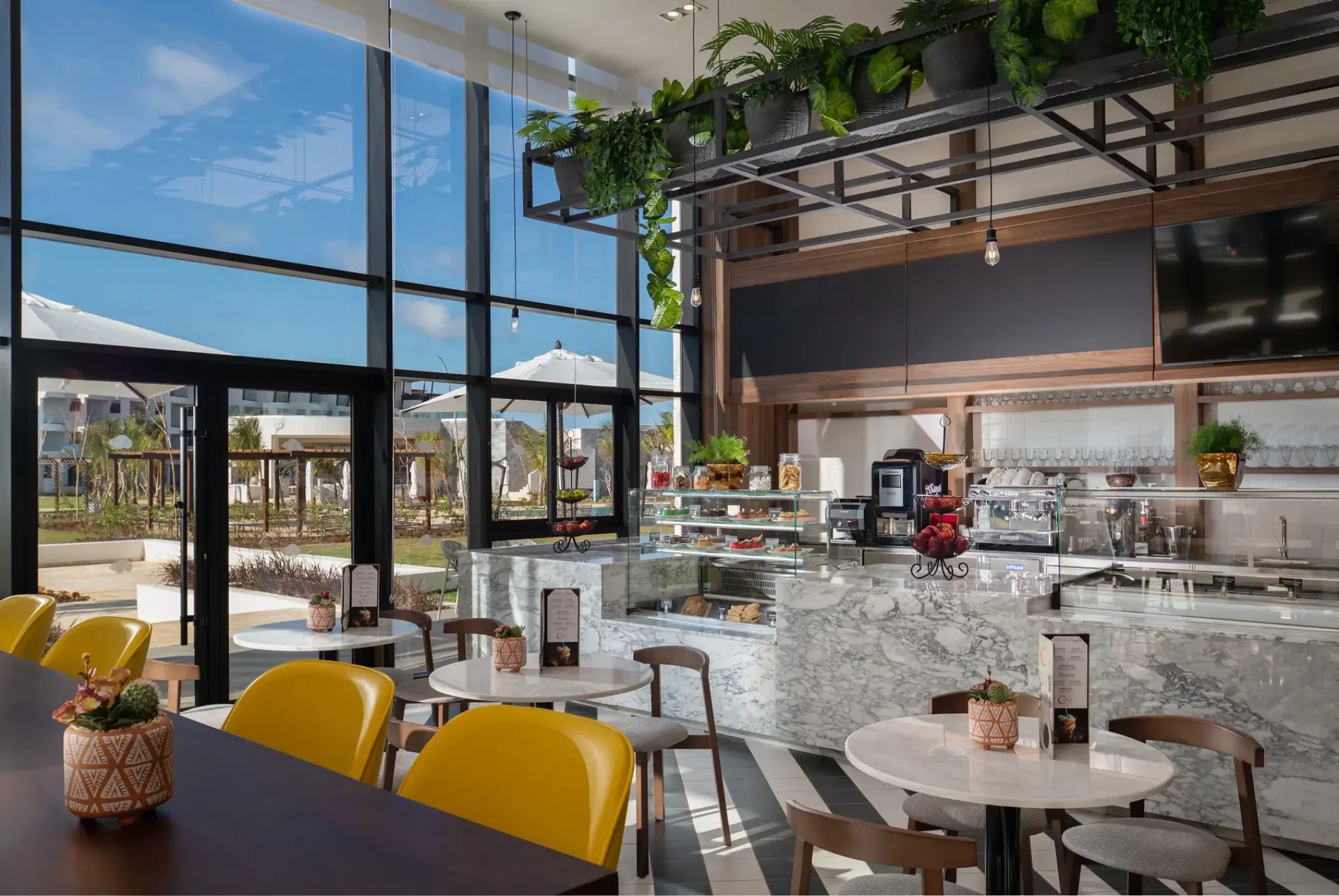 Coco Cafe at Dreams Macao Beach featuring marble counters and bright yellow seating, Punta Cana