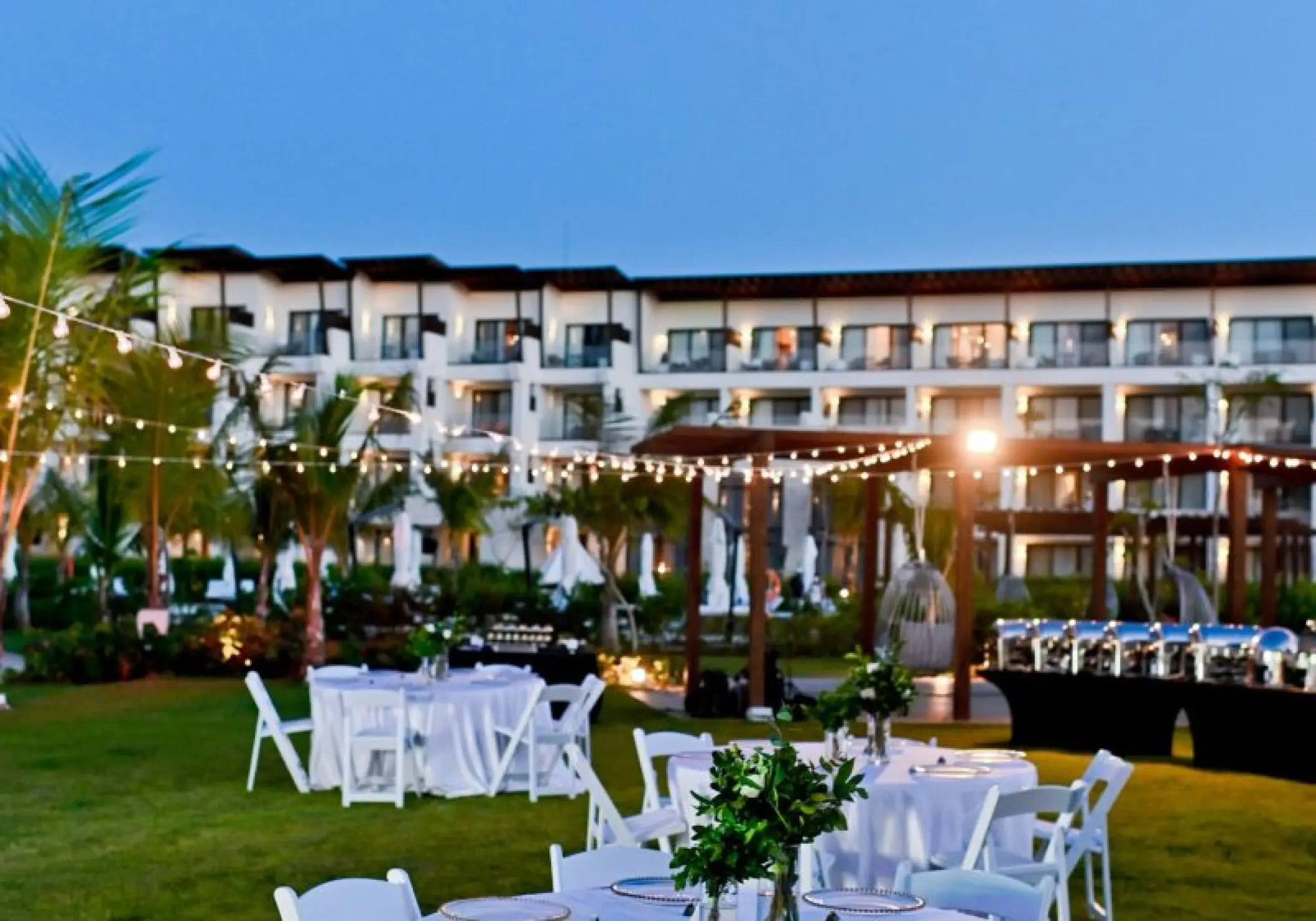 Evening wedding reception setup with string lights on the garden terrace at Dreams Macao Beach, Punta Cana
