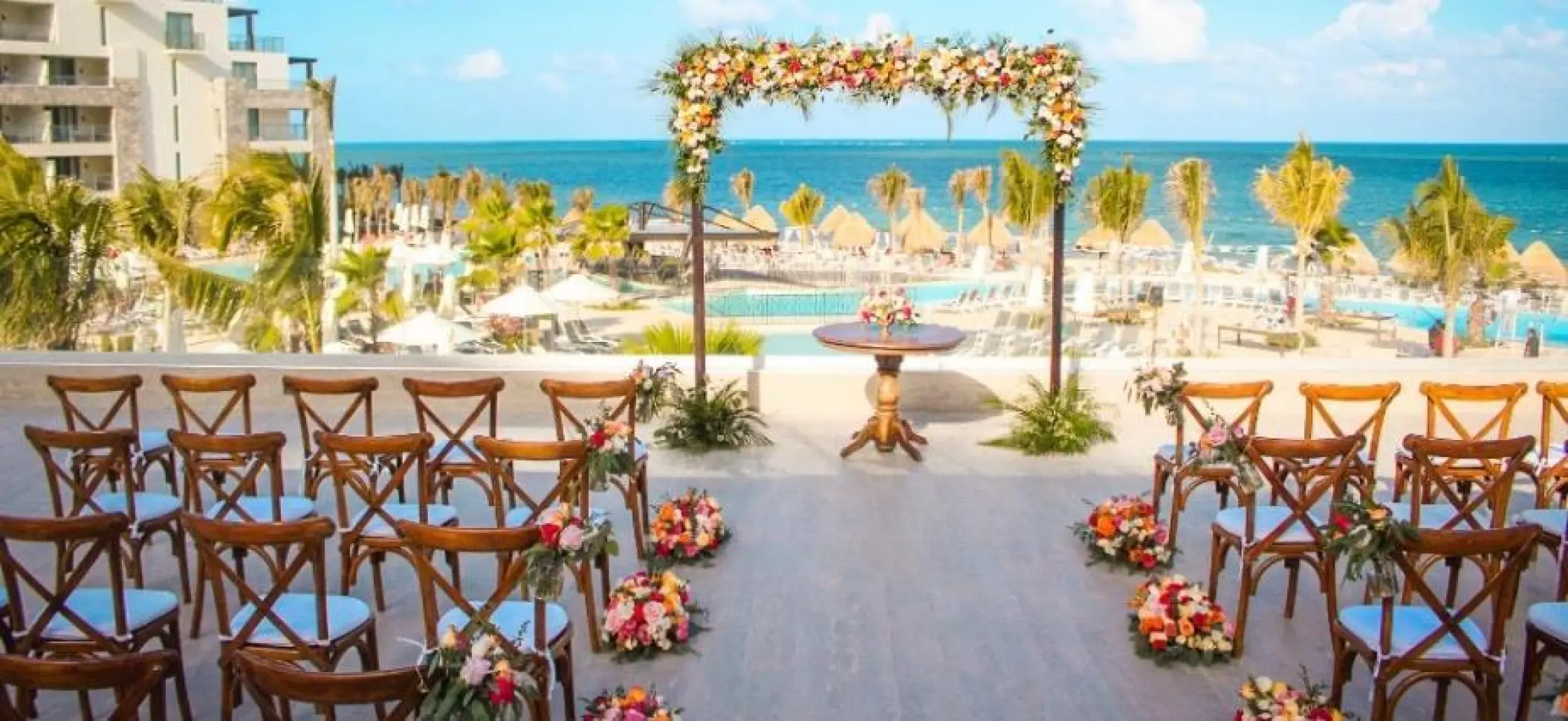 Rooftop wedding ceremony setup with floral arch at Dreams Natura, Riviera Maya