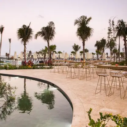 Outdoor wedding reception setup on the fishpond terrace at Dreams Natura, Riviera Maya