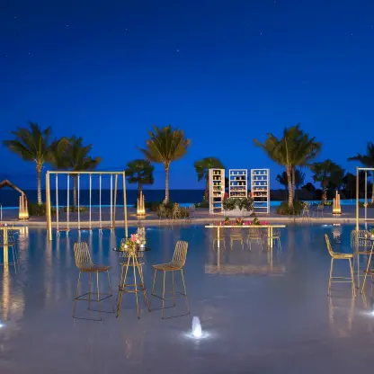 Evening wedding reception setup on a shallow pool terrace at Dreams Natura, Riviera Maya