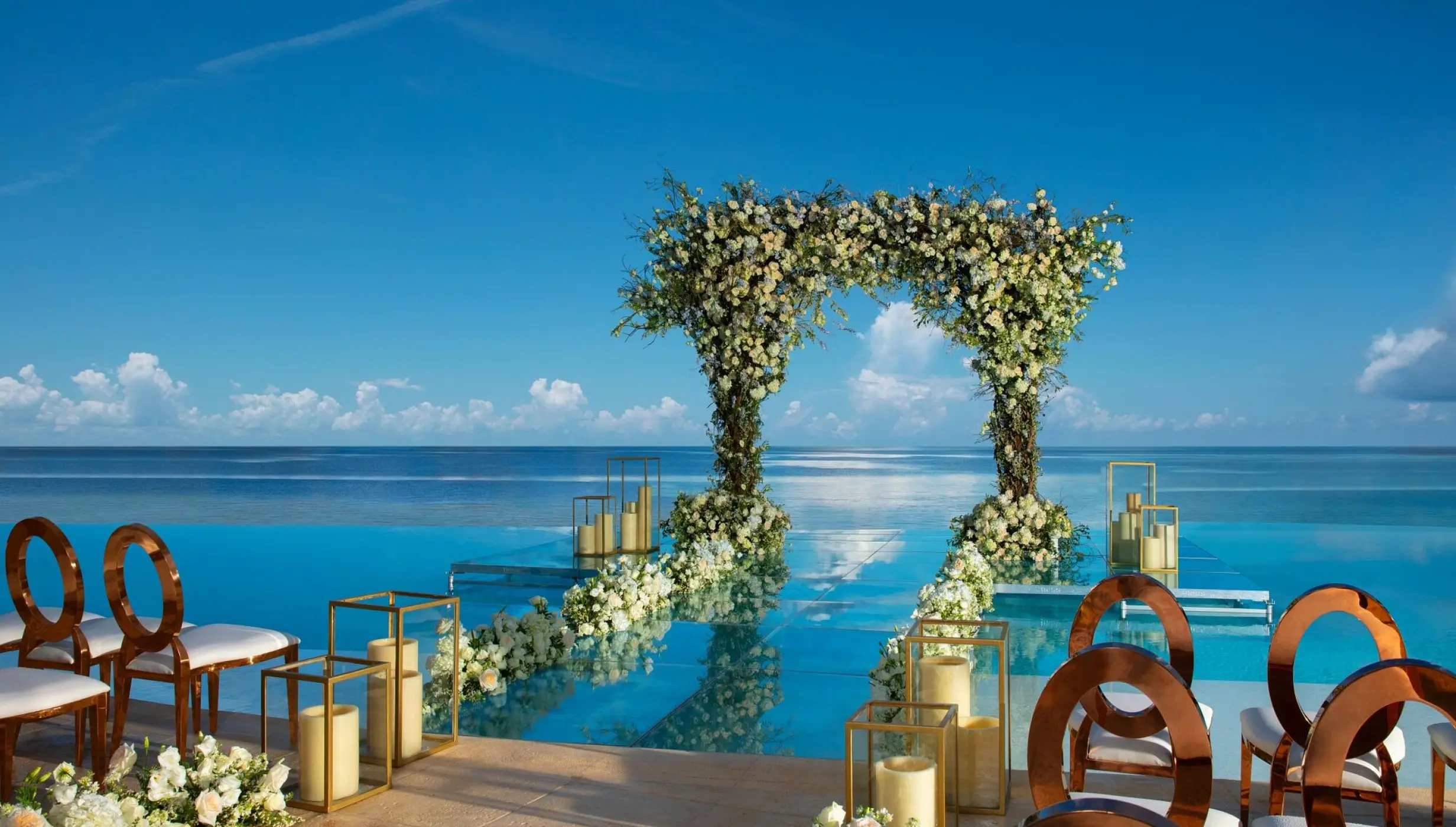Floral arch at an infinity pool wedding ceremony at Dreams Natura, Riviera Maya